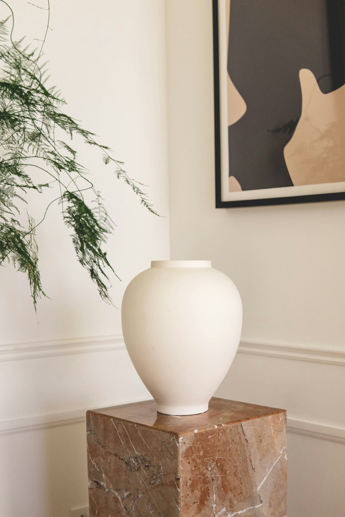 Hand-thrown ceramic vase on warm neutral pedestal